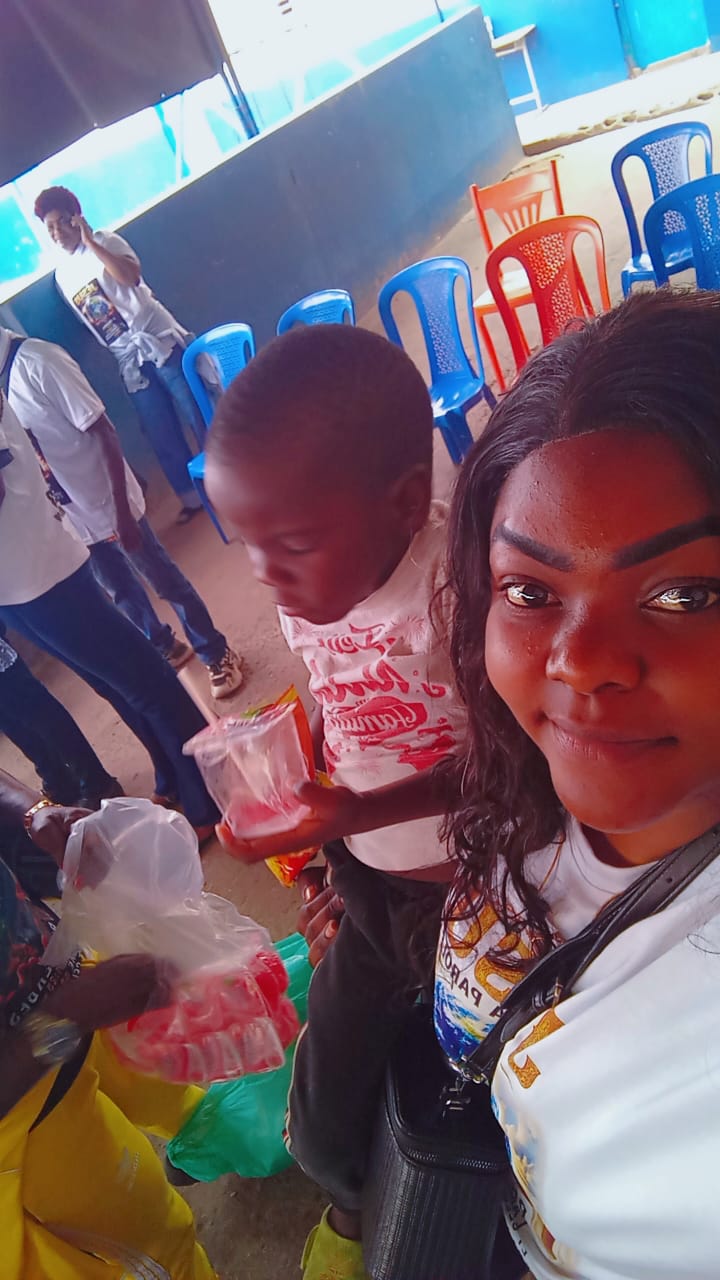 A volunteer handing out sweets and drinks to a young child