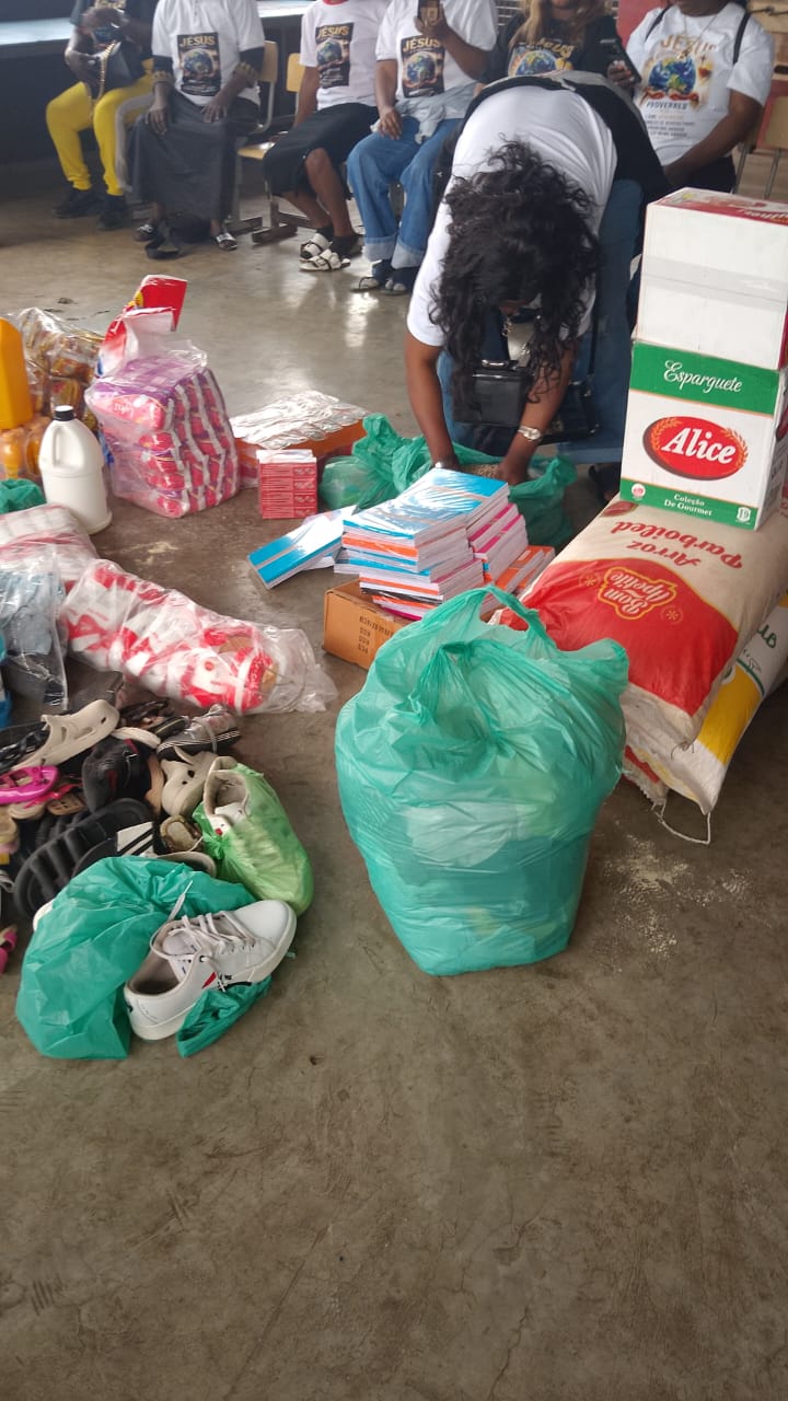 A volunteer sorting exercise books and supplies during a school donation day