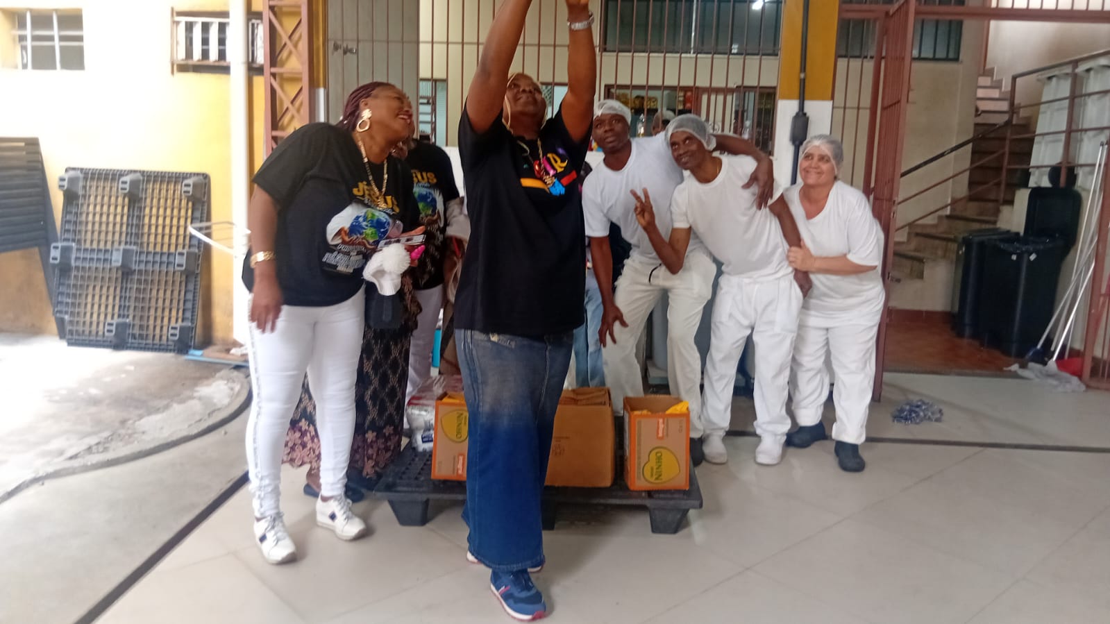 Volunteers celebrating with kitchen staff after delivering food donations