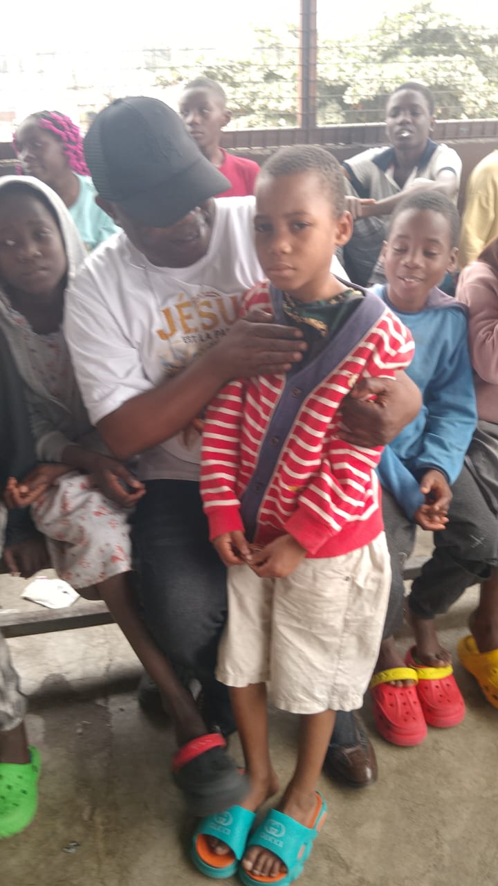A volunteer fitting warm clothing on a child during a clothing distribution