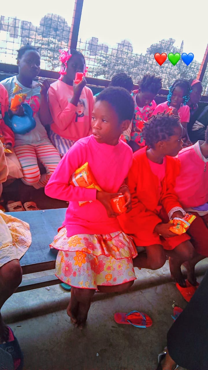 Young girls holding snacks and cups received at a community outreach
